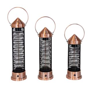 Three copper lantern style patio heaters in varying sizes