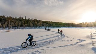 Exodus group cycling over a frozen lake