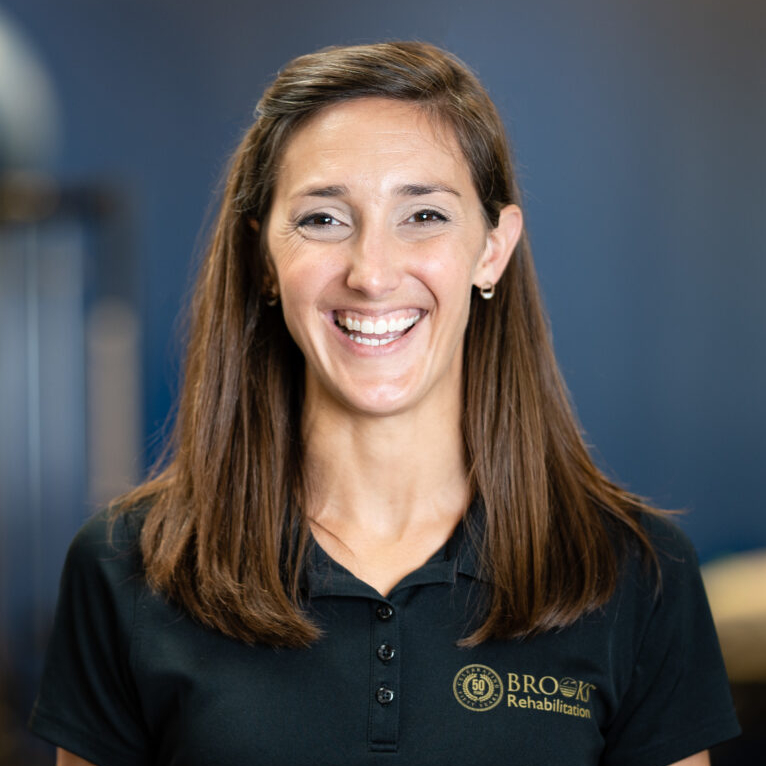 Head and shoulders of smiling woman wearing a black polo shirt