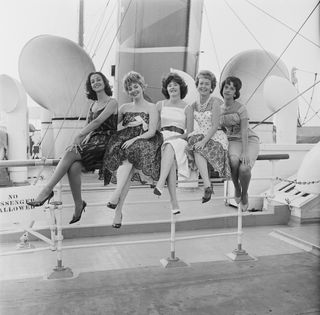 60s fashion - women in dresses on a boat