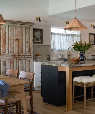 transitional kitchen diner with white cabinetry, vintage furniture and a navy island