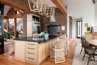 kitchen with wooden floor and island with rattan chair and brick walls