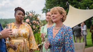 Jo Martin as Suzie, Cara Horgan as Becks and Samantha Bond as Judith hold drinks at a garden party in The Marlow Murder Club.