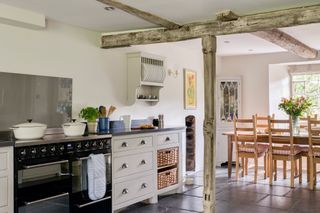 kitchen dining room with range cooker and cabinets and exposed timber beams