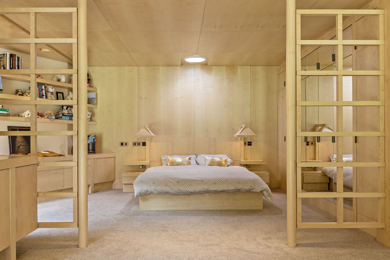 The bedroom with neutral colouring and wood framed dividers