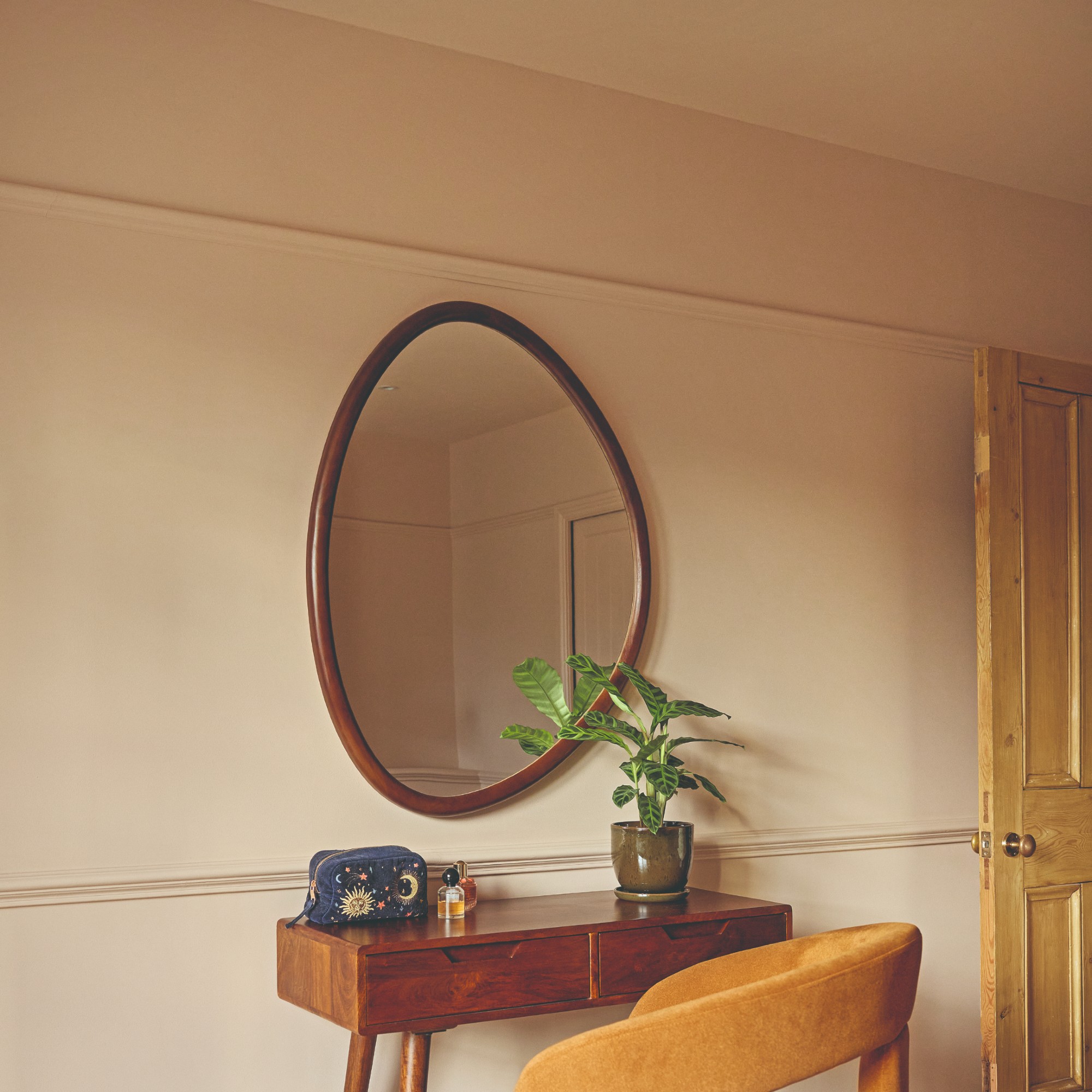A pink bedroom painted in Little Greene's Masquerade with Masquerade Light on the ceiling and a dressing table set against the wall