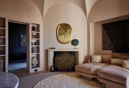 lime washed sitting room in terracotta with pink sofa, and natural colored artworks 