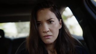 Violet (Olivia Munn) looks on while driving in Violet