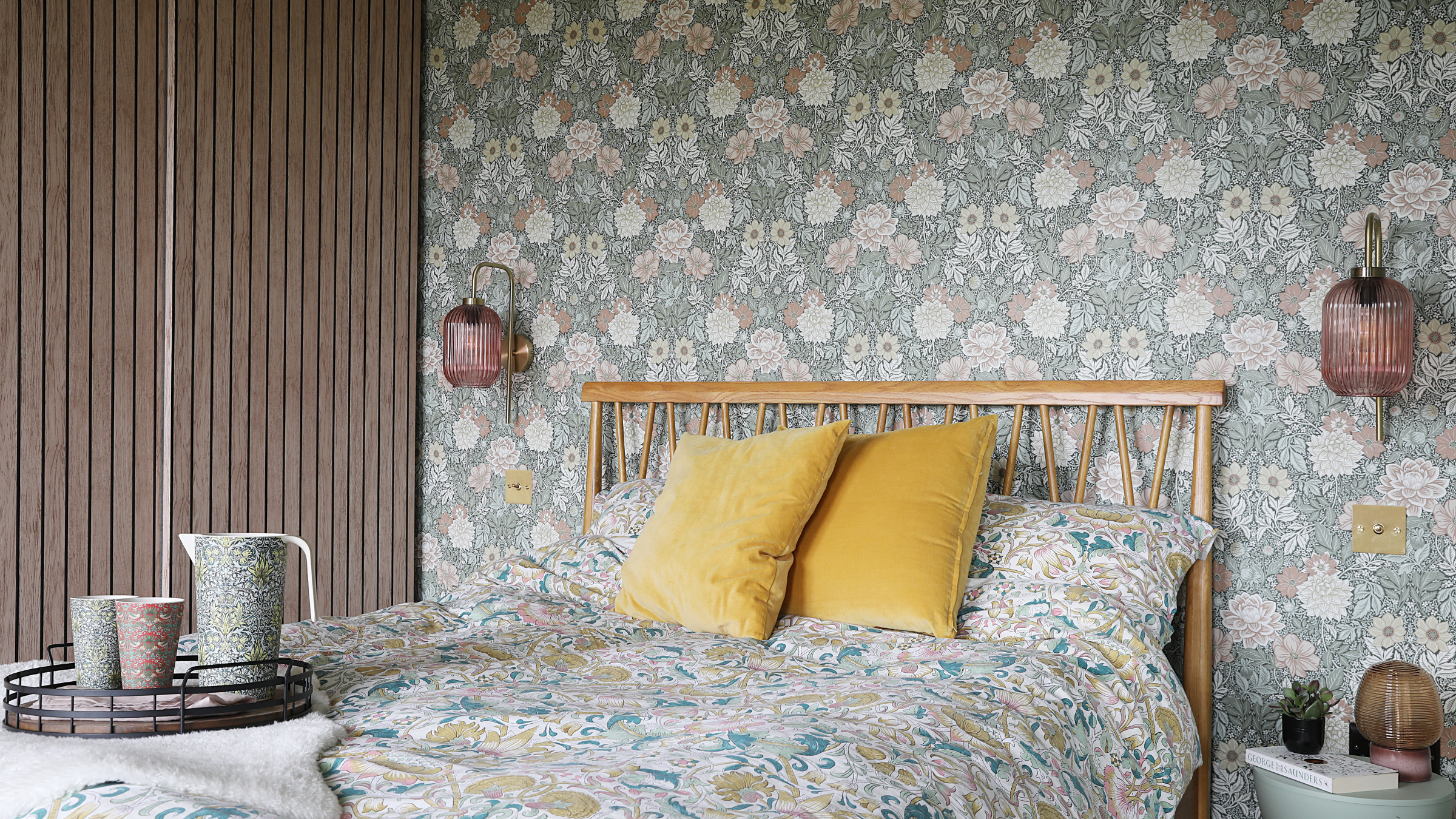 Double bed with floral bedding and yellow cushions.