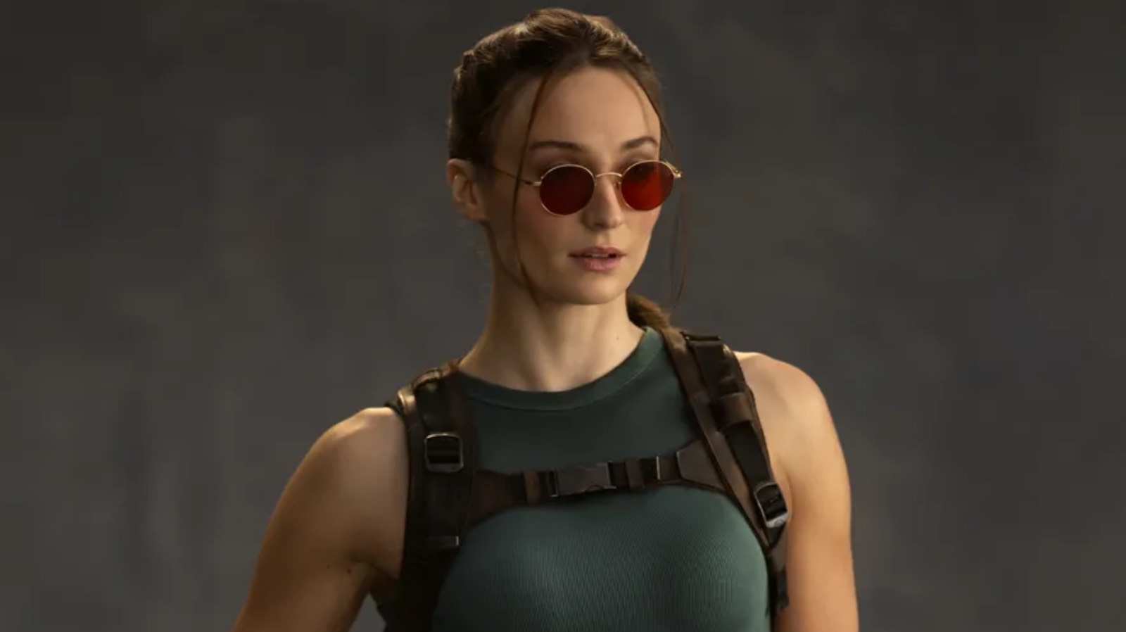 Sophie Turner dressed as Lara Croft for the Tomb Raider television show wearing sunglasses