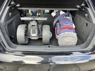 The Motocaddy M3 GPS Electric Trolley and a set of golf clubs in a car boot