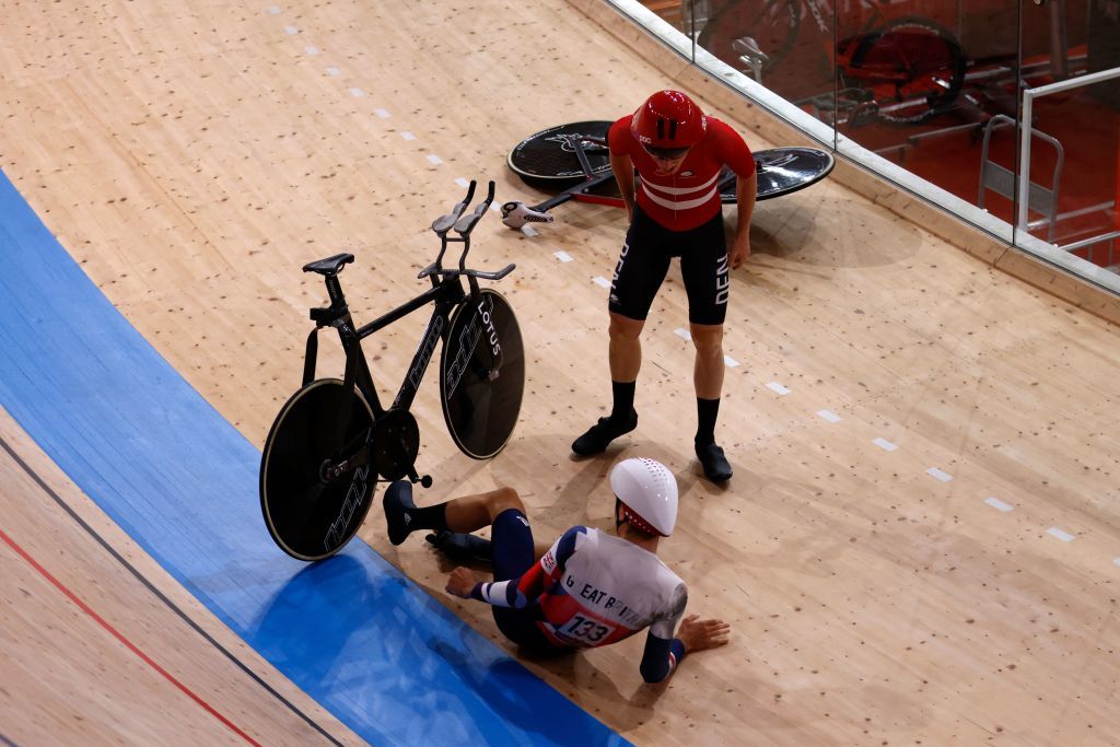 Denmarks Frederik Rodenberg Madsen reacts after crashing with Great Britains Charlie Tanfield during the first round heats of the mens track cycling team pursuit during the Tokyo 2020 Olympic Games 