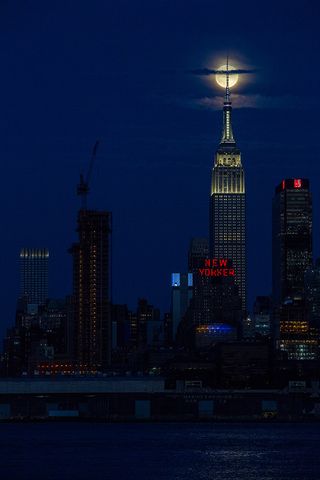 The full Thunder Moon rises behind the tip of the Empire State Building in New York City on Saturday (July 8) at 10:56 p.m. EDT (0256 GMT on July 9).