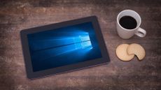 A tablet on a table showing the Windows 10 logo