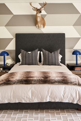 teenage boy bedroom with grey headboard and deer head on wall