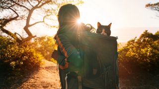 Woman hiking with cat in backpack