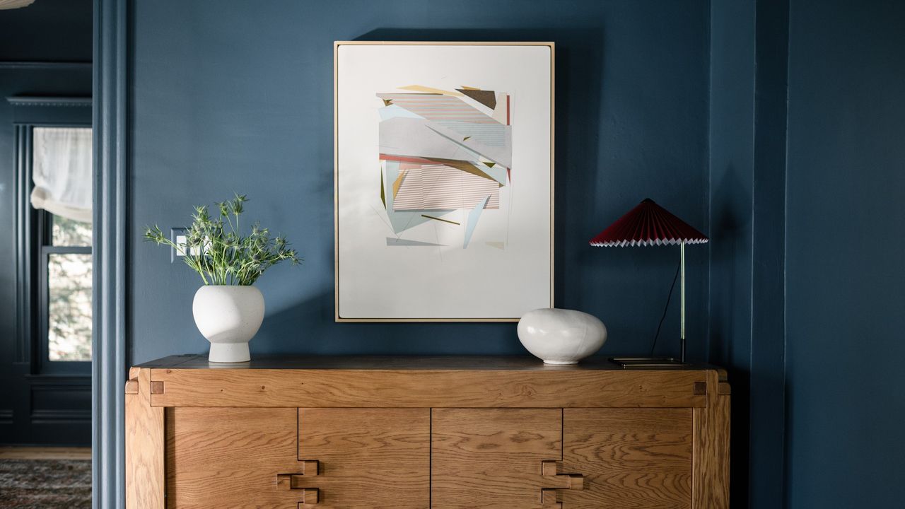 A passageway with brown furniture and dark blue walls