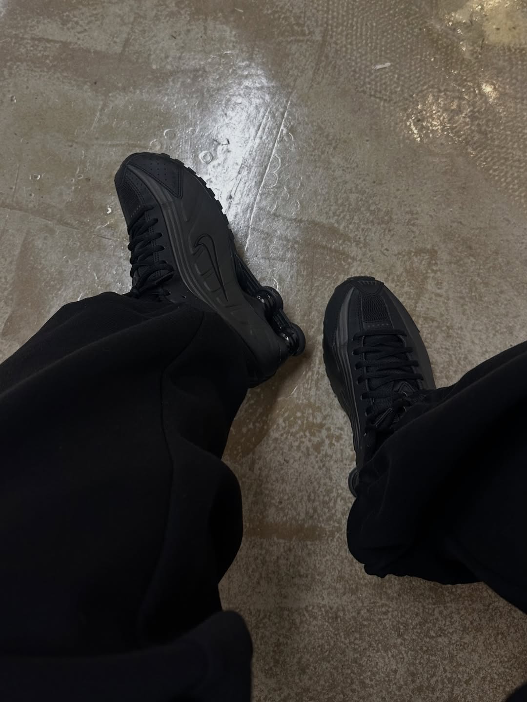 Alexis Foreman photographs herself wearing Nike Shox R4 trainers in black with black trousers.