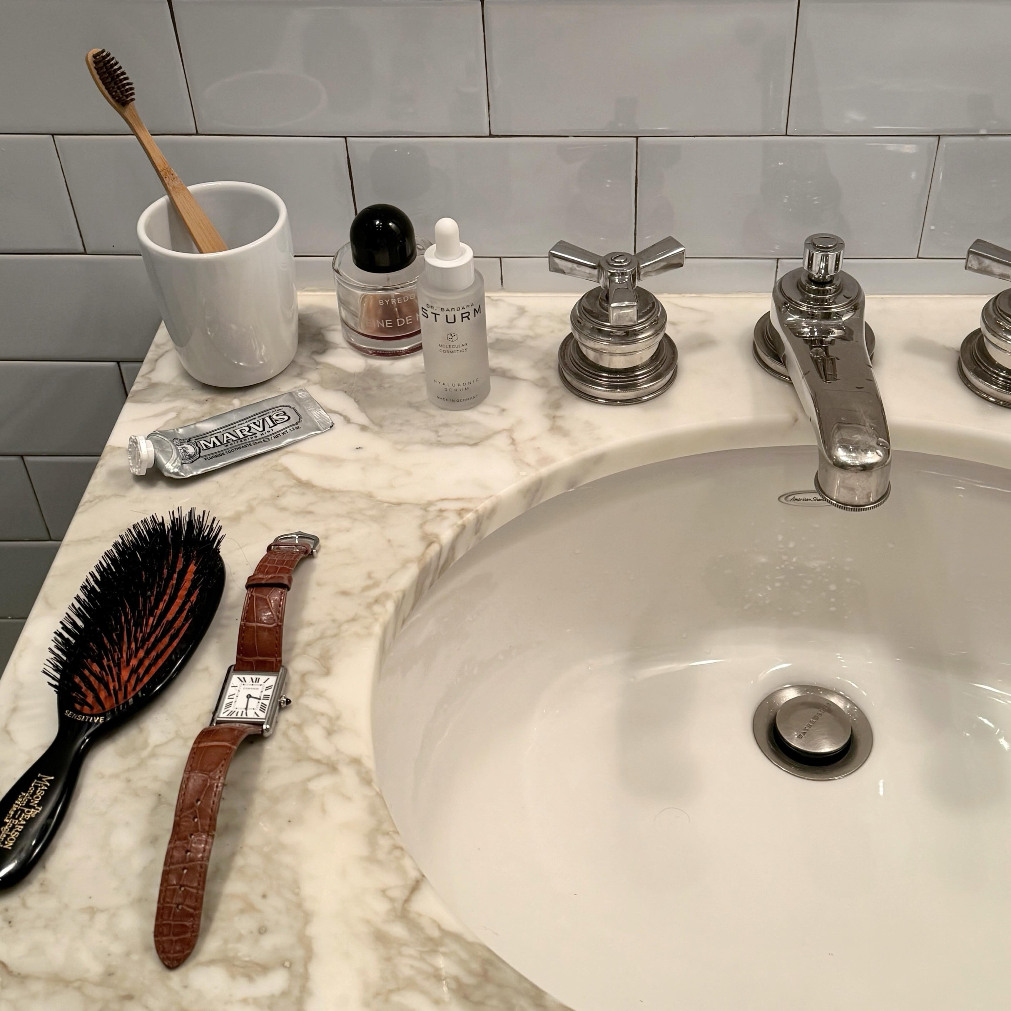 A marbled vanity in a bathroom with skincare products
