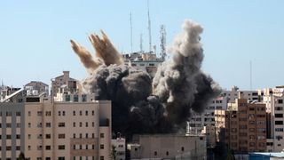 A thick column of smoke rises from the al-Jalaa tower as it is destroyed in an Israeli airstrike in Gaza city controlled by the Palestinian Hamas movement, on May 15, 2021. Israel's air force targeted the 13-floor Jala Tower housing Qatar-based Al-Jazeera television and the Associated Press news agency.