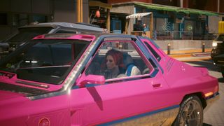 V in Cyberpunk 2077 in the driving seat of a pink car she just hijacked.