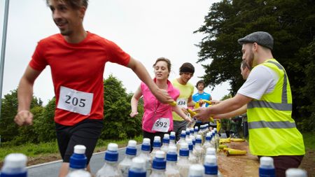 runners being passed bananas and water during the berlin marathon