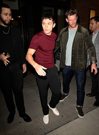 Tom Holland wears a burgundy t shirt and pants to match Zendaya while on a date in New York City