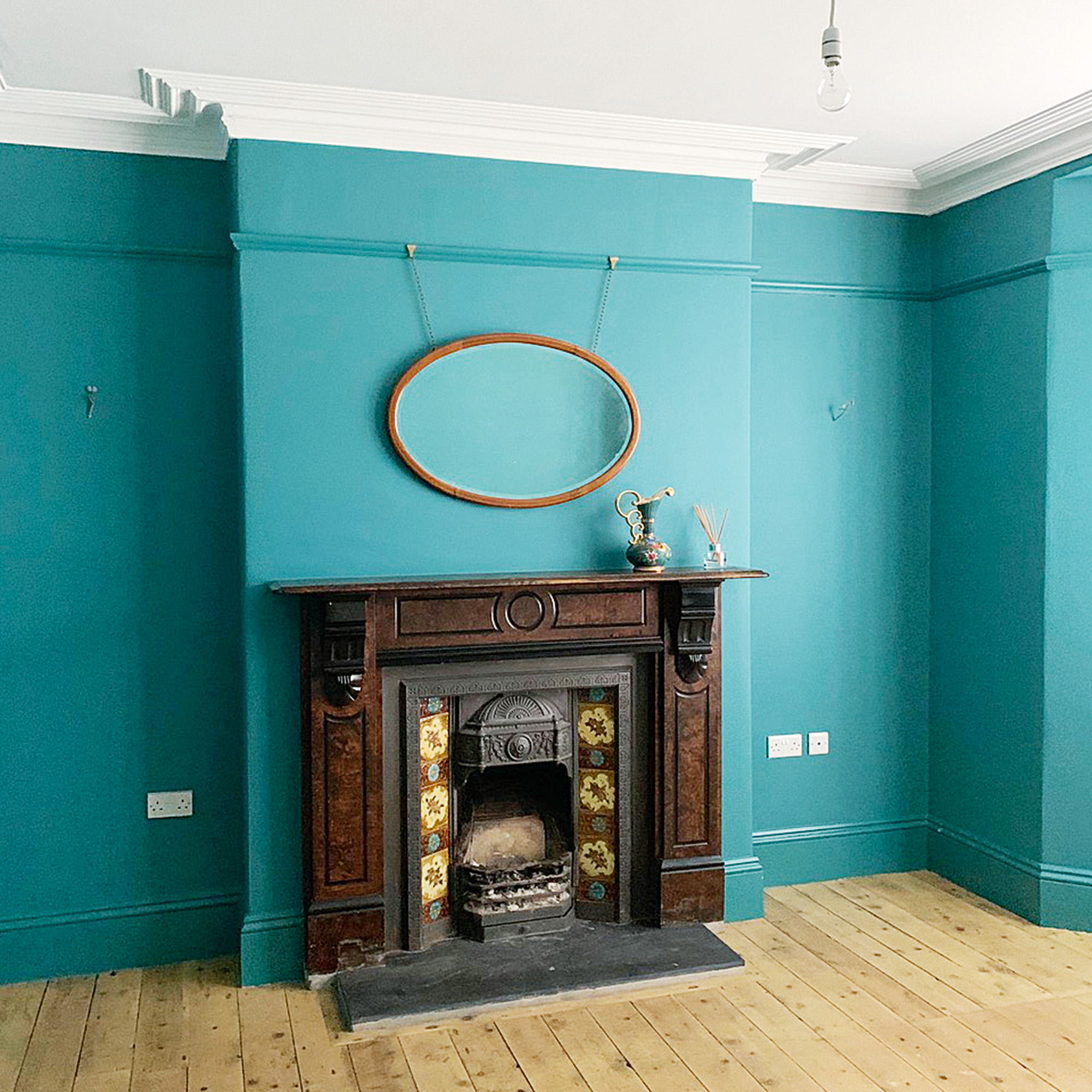 teal living room with victorian fireplace before photo