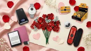 A collection of Valentine's Day gifts on a pink satin cloth with cutout paper hearts and rose petals