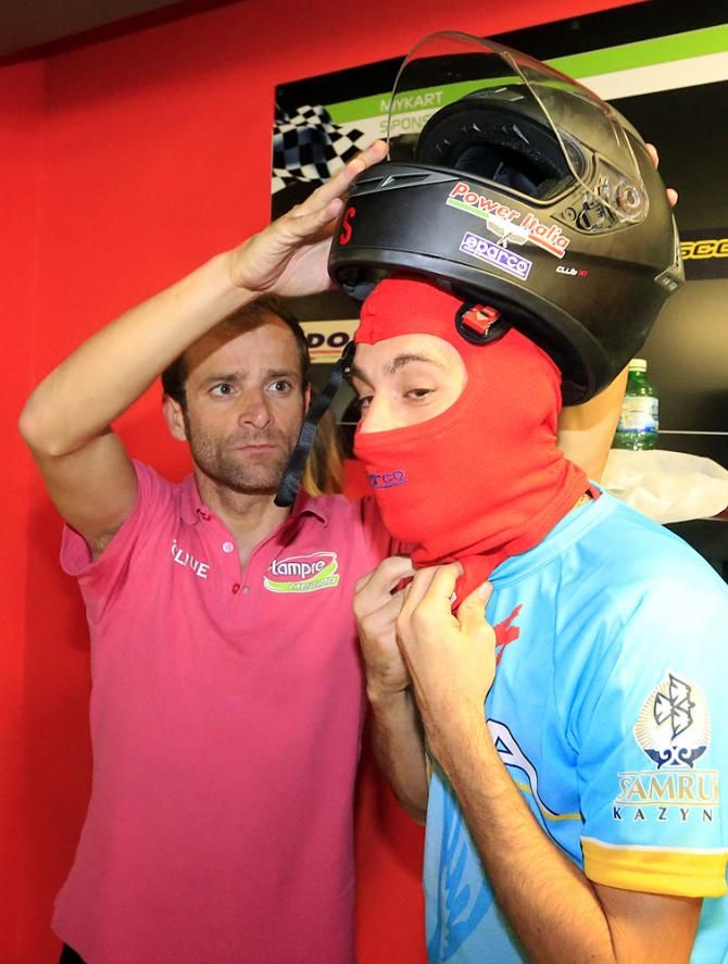 Vincenzo Nibali gets help with his helmet from new teammate Michele Scarponi