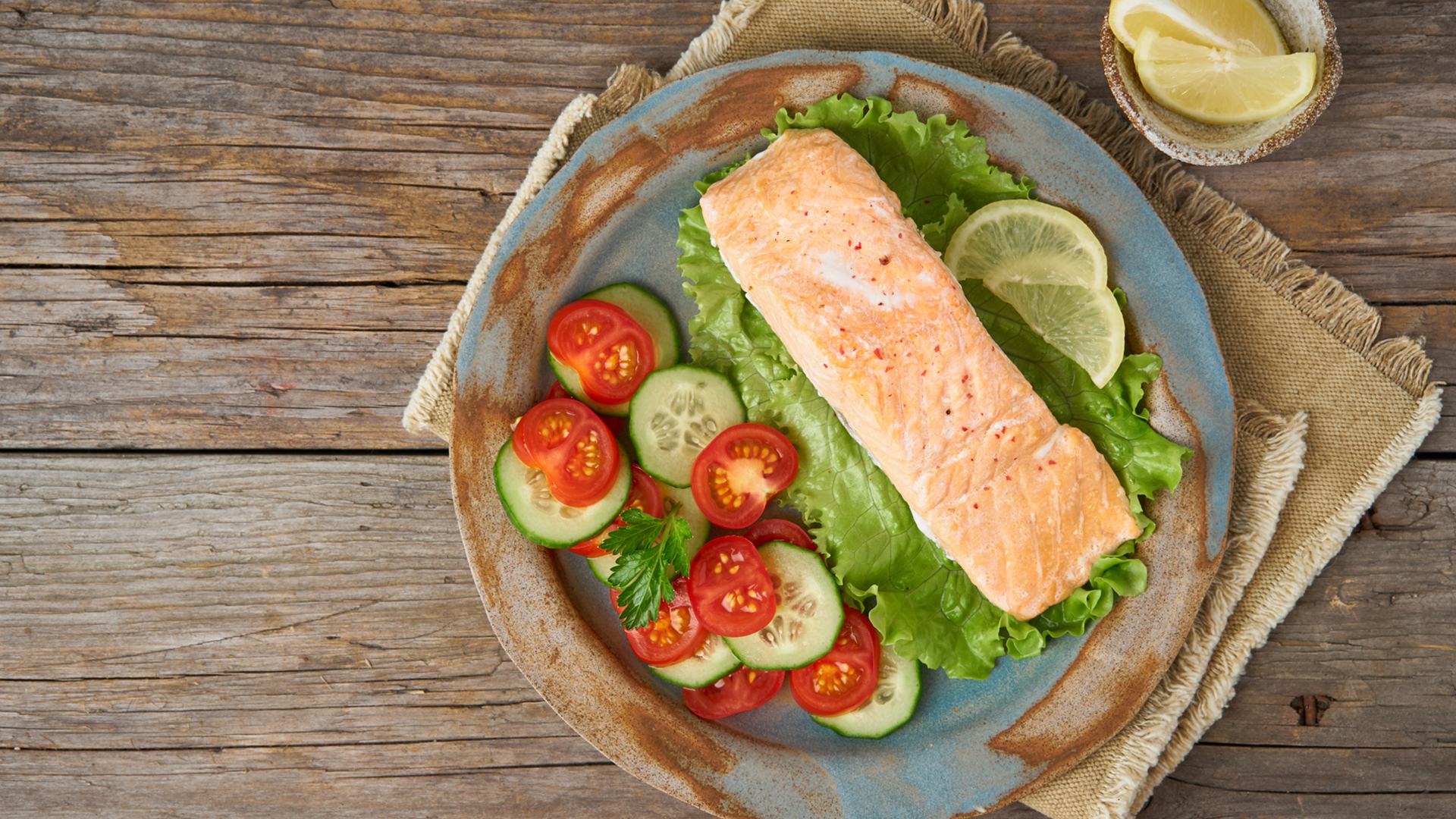 plate of salmon with lettuce, tomatoes and cucumber