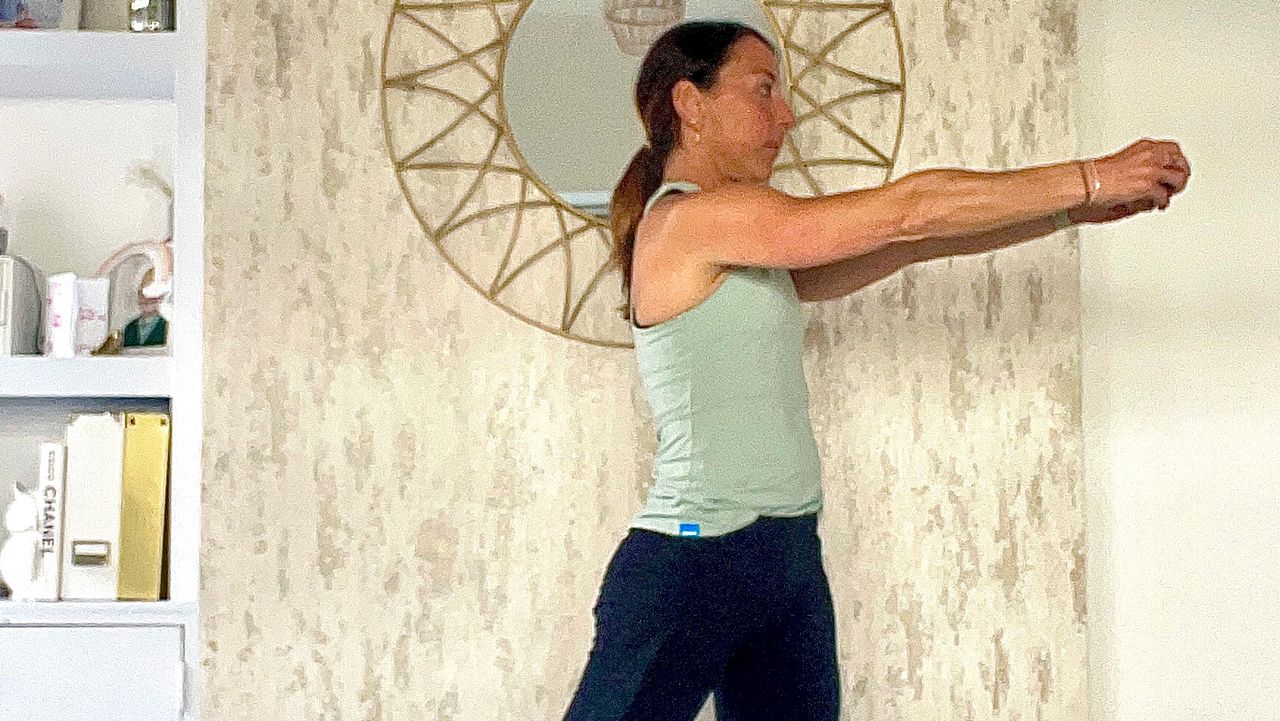 Lucy Miller performing standing oblique twists while holding a dumbbell