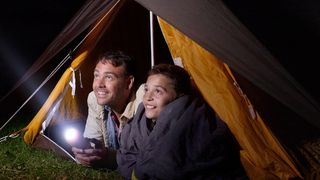 最佳露营手电筒:父子俩在帐篷里拿着手电筒