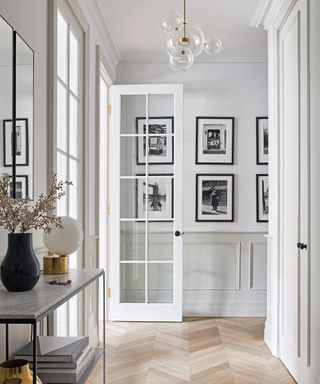 A modern hallway idea with French doors, contemporary orb chandelier and console table