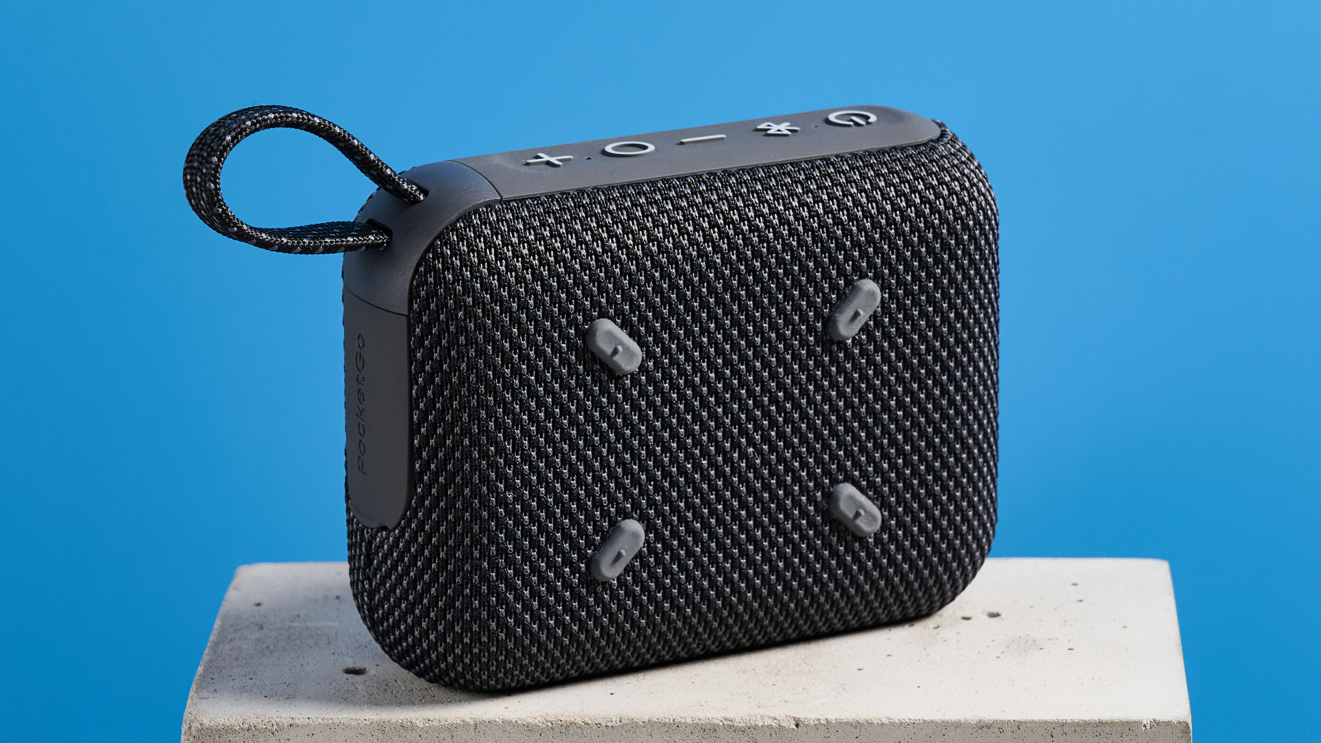The Tribit PocketGo speaker in black photographed on a blue background.