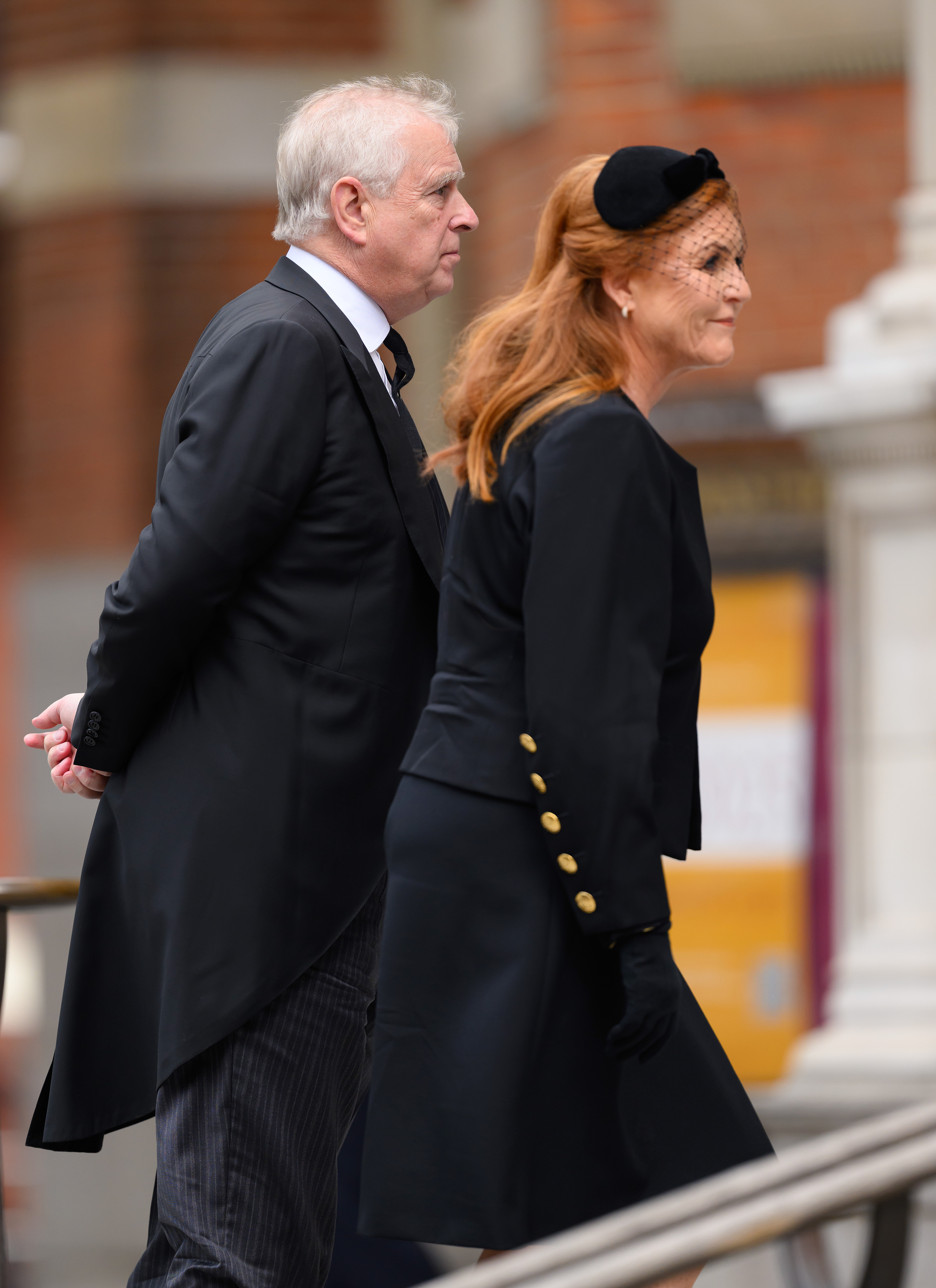 Sarah Ferguson and Prince Andrew walking next to each other wearing black at the Duchess of Kent's funeral
