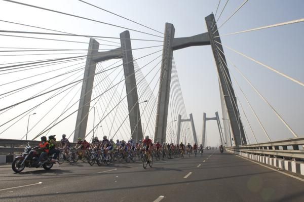 The peloton cross a bridge during the first of two races