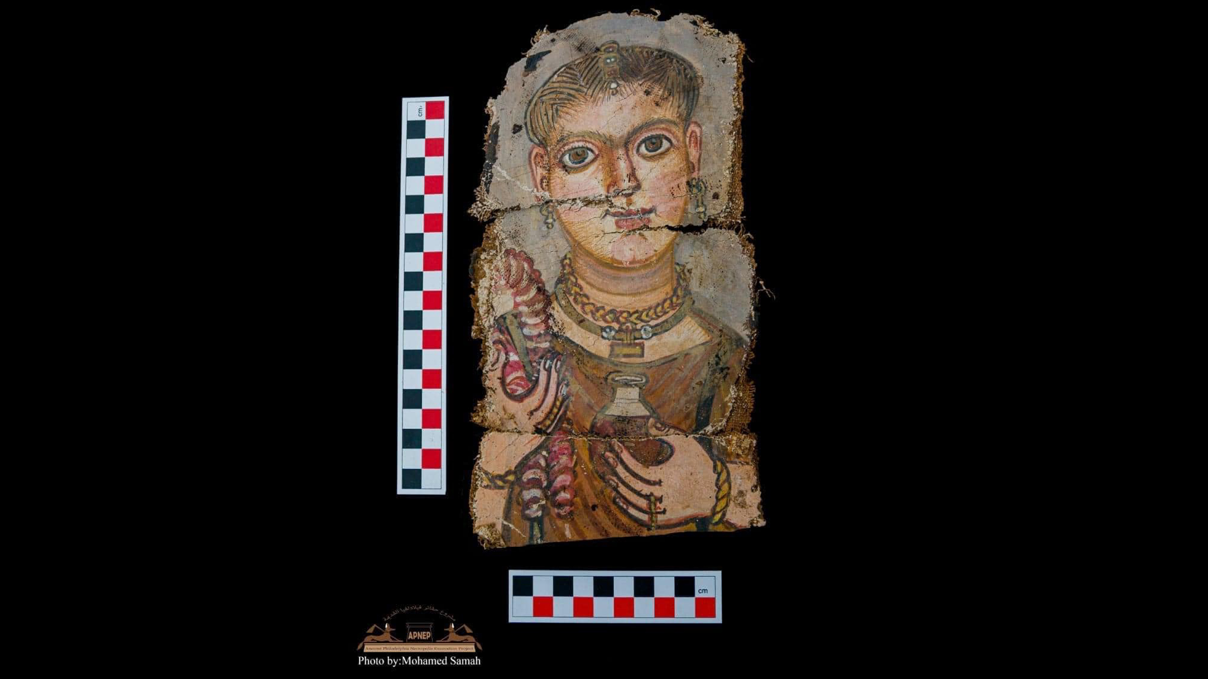 One of the newfound mummy portraits, seen here, is painted on a linen shroud.