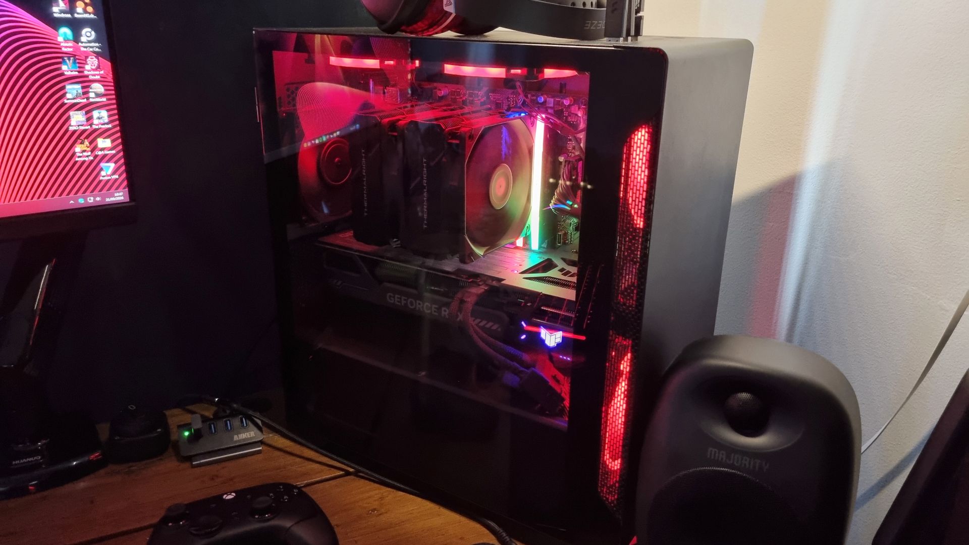 A red-RGB-lit gaming PC and desk setup