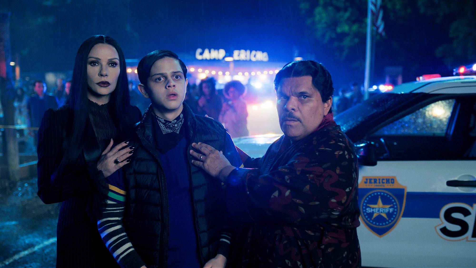 Catherine Zeta-Jones as Morticia Addams, Isaac Ordonez as Pugsley Addams, and Luis Guzmán as Gomez Addams in "Wednesday" season 2 on Netflix