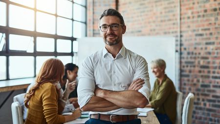 Cropped shot of a businessman standing in the office with his arms folded looking confident and smiling at the camera