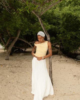 Woman wearing yellow top and white skirt on the beach