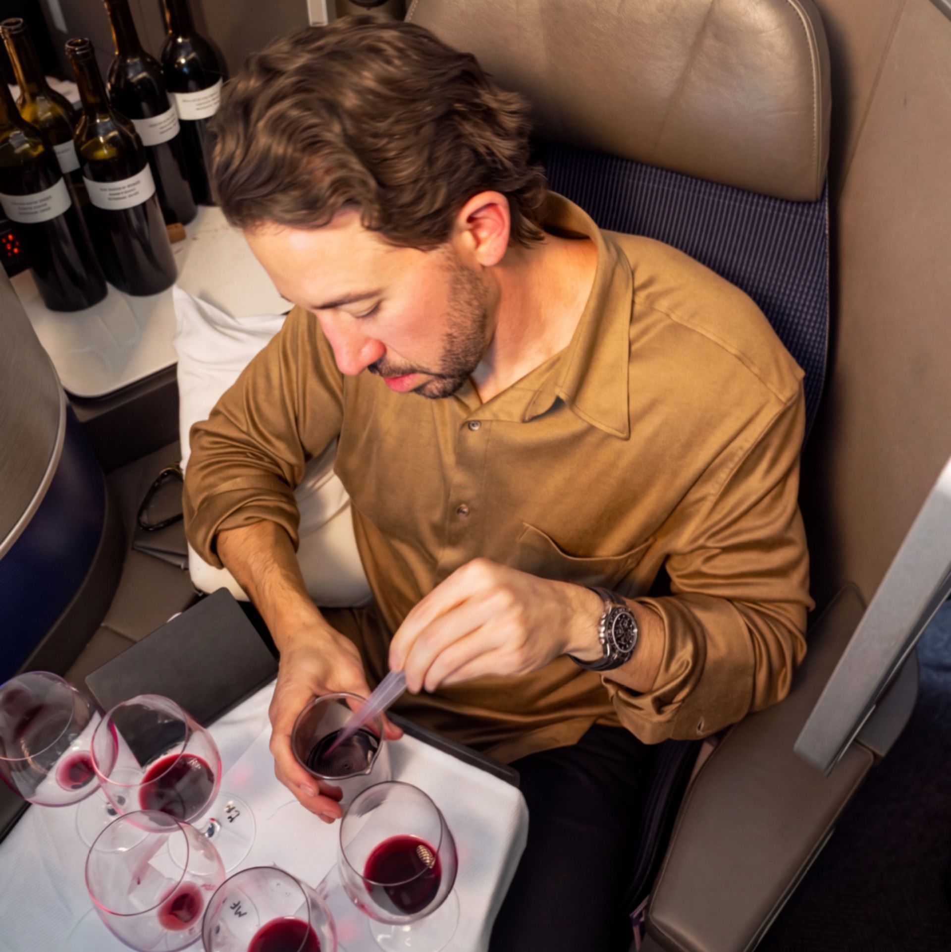 Aperture winemaker Jesse Katz blending red wine on a United Airlines flight in Polaris business class