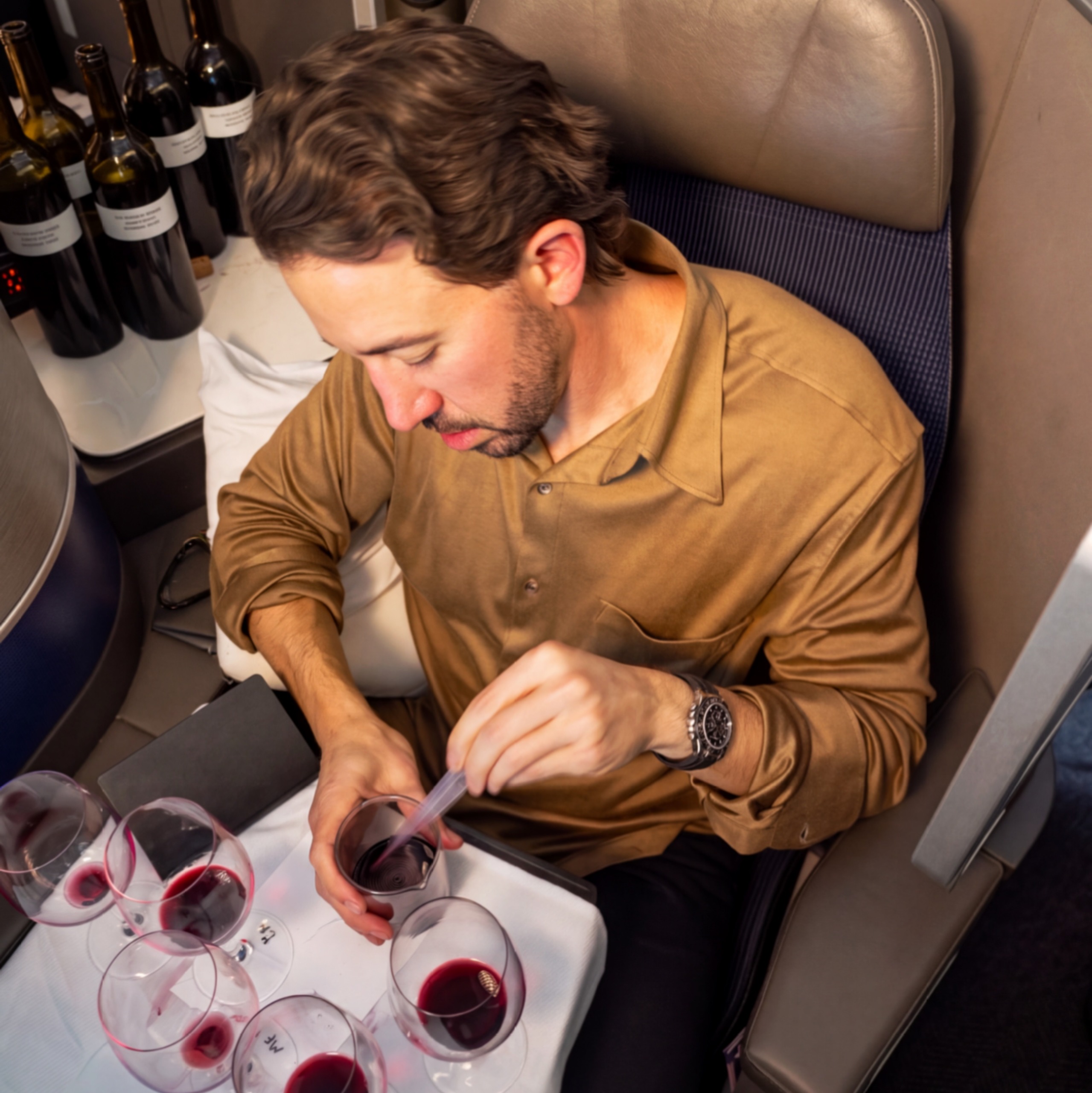 Aperture winemaker Jesse Katz blending red wine on a United Airlines flight in Polaris business class