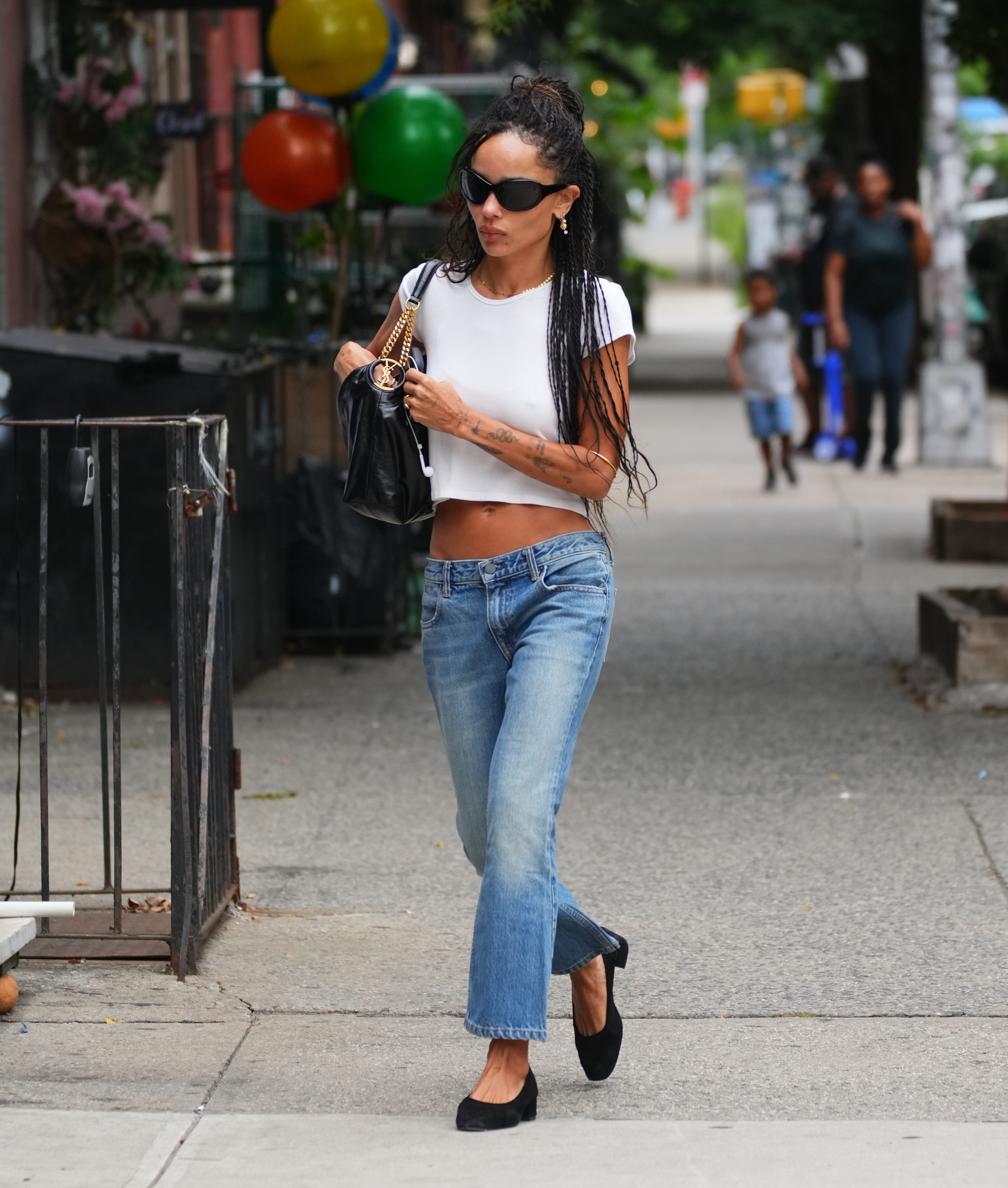 Zoe Kravitz wears the ballet flats trend with distressed jeans and white T-shirt on August 22, 2026 in New York City