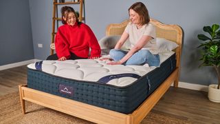 Tom's Guide mattress writers sit on top of the DreamCloud Luxury Hybrid mattress during the testing process at our Sleep Lab