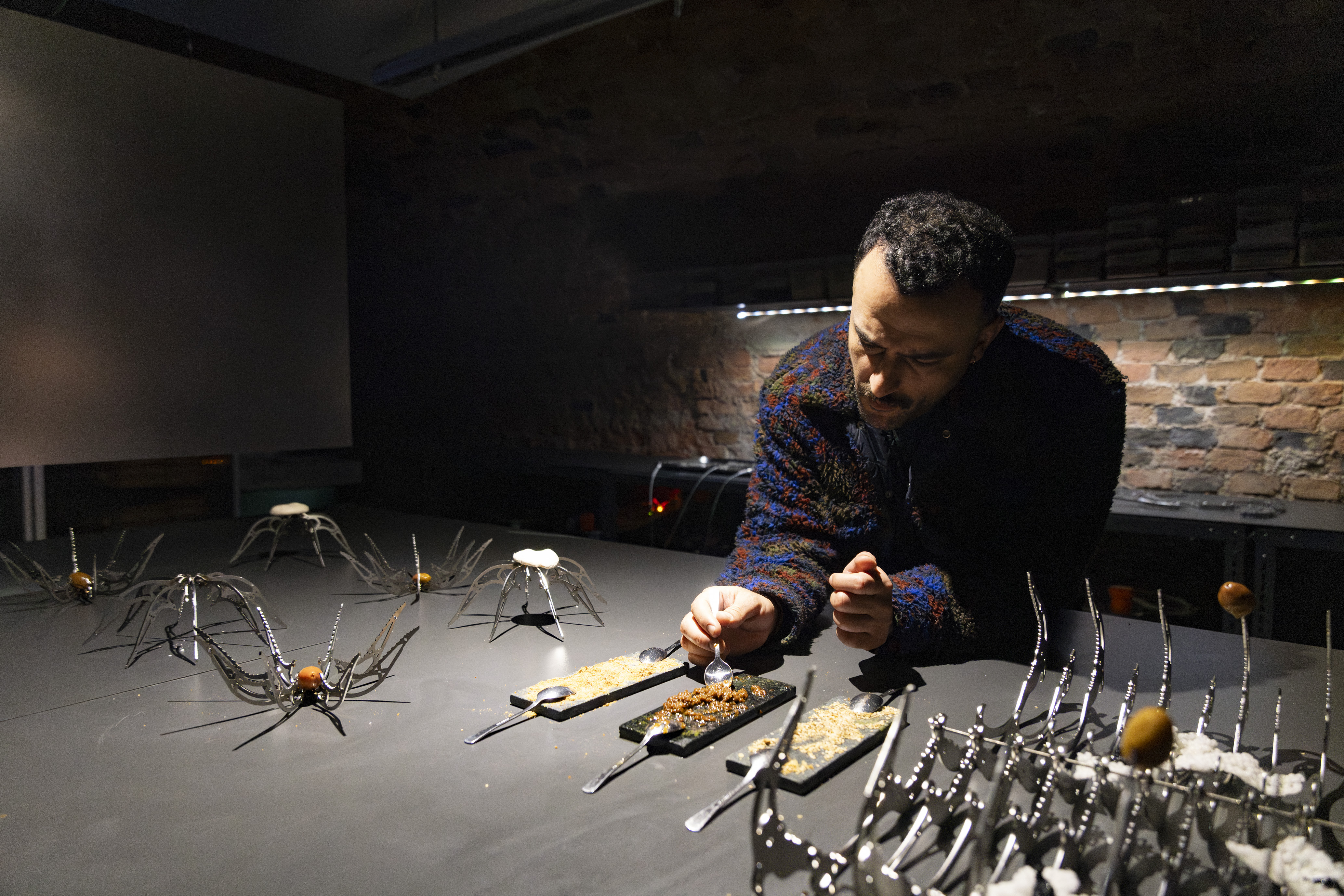 Dark room with person cooking with tools