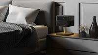 Epson EF-73 sitting on a monochrome bedside table emitting a golden light onto its stand