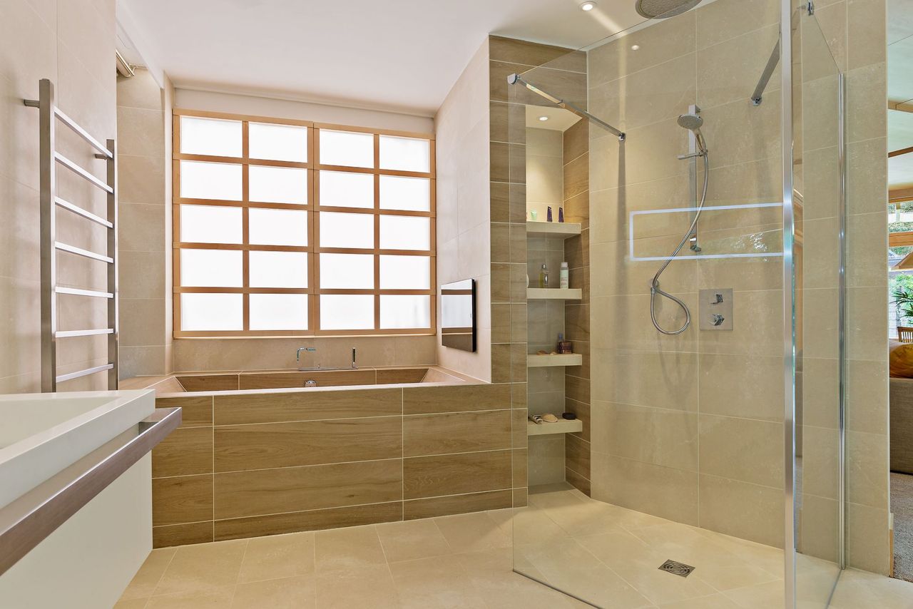 The bathroom in the zig zag home with stone tiling and double sinks