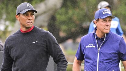 Phil Mickelson and Tiger Woods watch golf shot